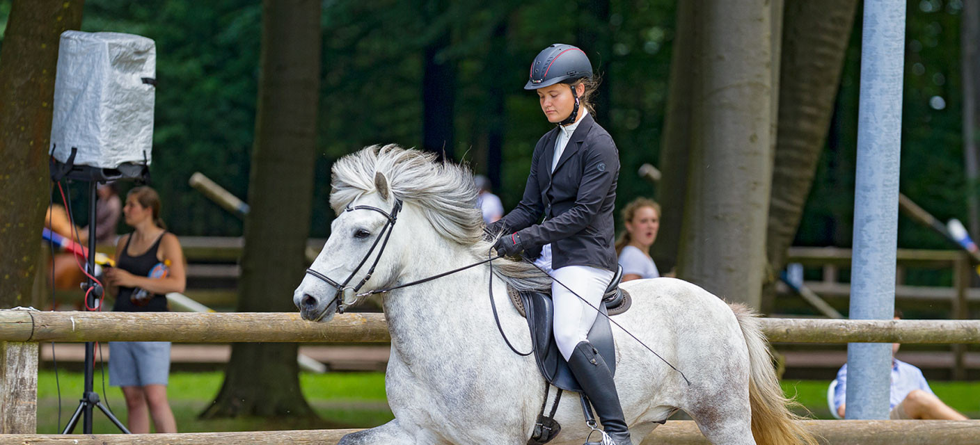 eine Frau, die an einem Wettbewerb mit isländischen Pferden teilnimmt